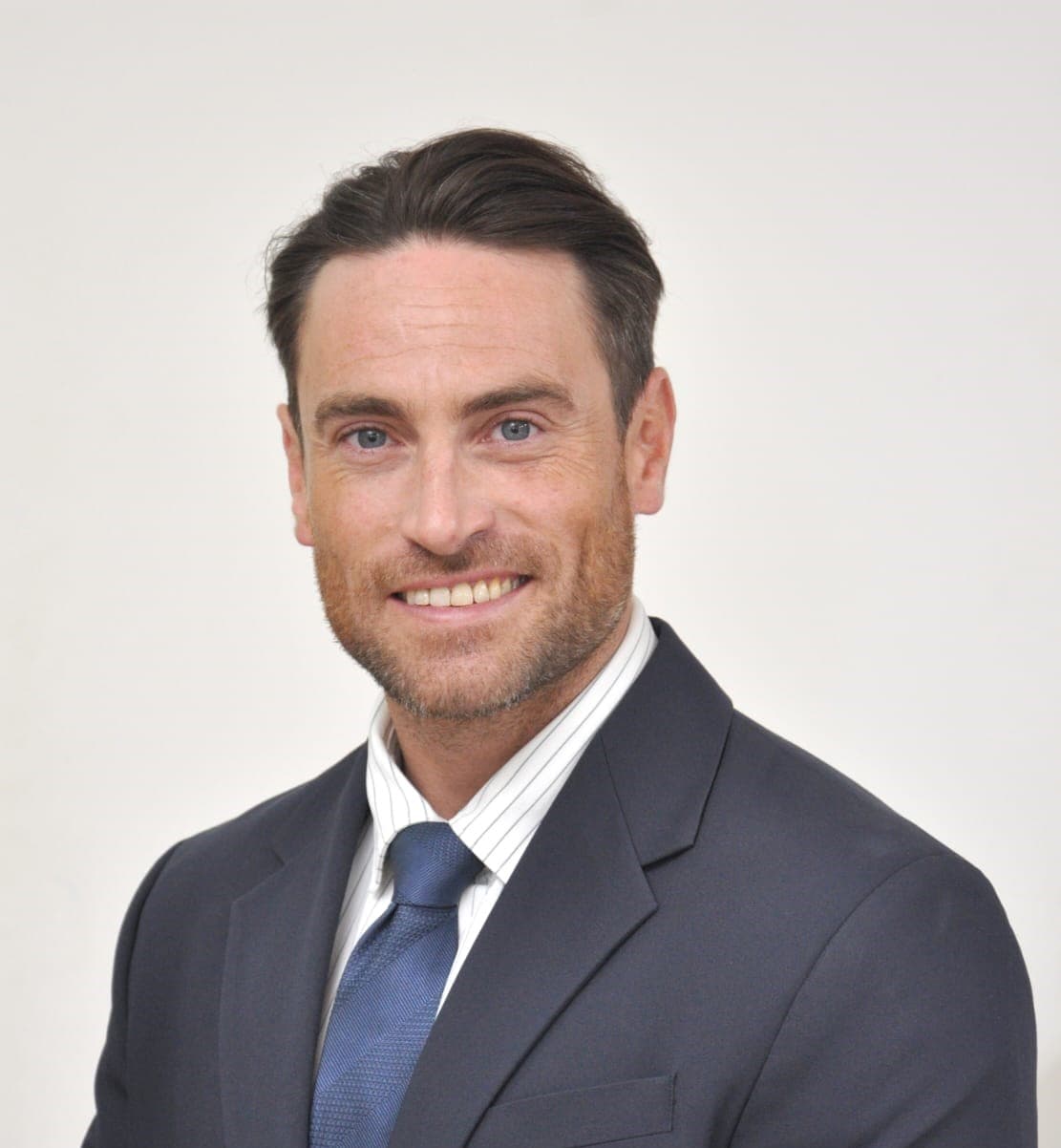 Professional headshot of a smiling male lawyer in a suit